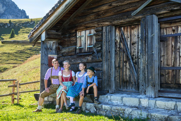 Young Bavarian family in a beautiful mountain landscape. Happy parents and smiling kids in...