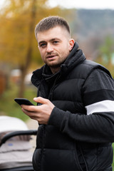 Hipster using a touch screen smart phone hands close up, vintage colors. Man using mobile smartphone - focus on top of the phone. meeting with business partners.