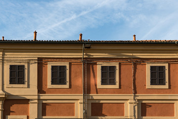 Fototapeta na wymiar orange apartments with brown shutters. Lugo, Italy