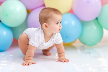 Fototapeta na wymiar Сute baby boy on the background of balloons