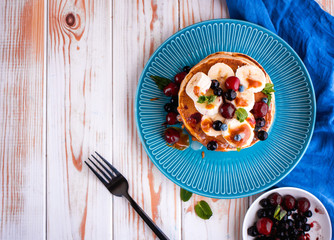 Delicious and lush pancakes with fresh fruits and berries, poured with salted caramel.