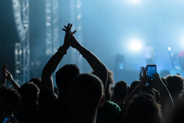 People having fun with their hands in the sky at the live music concert