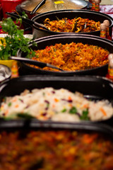 Street food, barbecuing on a hot grill with fire and smoke, thai food, vegetables and meat cooked for taking out. Brick Lane Food Market
