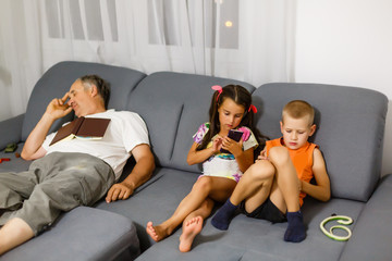 children play with your smartphone while grandfather is sleeping