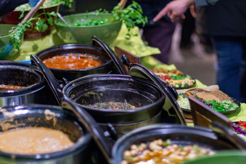 Street food, barbecuing on a hot grill with fire and smoke, thai food, vegetables and meat cooked for taking out. Brick Lane Food Market