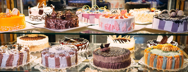 Pastry shop glass display with selection of cream or fruit cake.