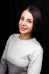 Portrait of serious beautiful female with black hair, has minimal makeup, looks calmly at camera,...