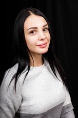 Portrait of serious beautiful female with black hair, has minimal makeup, looks calmly at camera,...