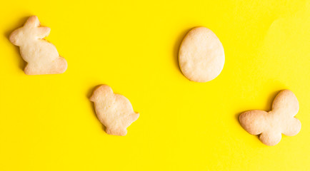 Easter cookies on yellow paper background. Easter symbols and traditions. Butter and sugar cookies.