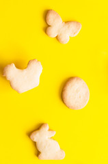 Easter cookies on yellow paper background. Easter symbols and traditions. Butter and sugar cookies.