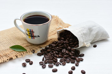 Traditional cup of Colombian coffee with coffee beans on wooden background