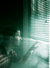 Man peeking through blinds as mystic light shines through, aliens?