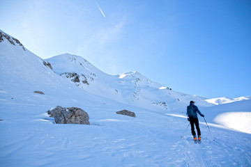 man making touring ski in a sunny day surrounded of mountains in Pyrenees