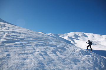 skier man going up of a mountain making touring ski in winter