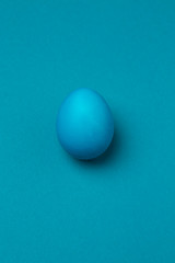 Easter egg in blue color on a blue background