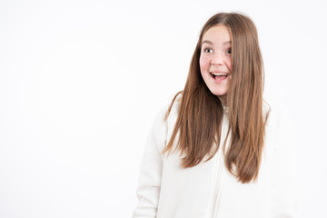 Naklejka premium Shocked female with red hair opened mouth and wide eyes looking at left side, dressed in casual clothes, isolated over white background
