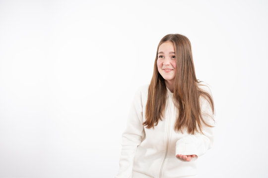Embarrassed readhead girl in white hoodie looking at left side isolated over white background