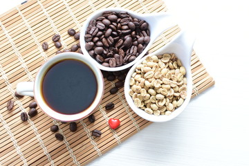 Traditional cup of Colombian coffee with coffee beans on wooden background