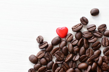  Processed coffee beans and tostao, with red heart on wooden background