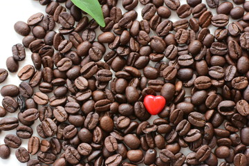  Processed coffee beans and tostao, with red heart on wooden background