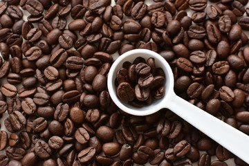 Processed coffee beans and tostao, on wooden background