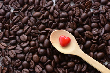  Processed coffee beans and tostao, with red heart on wooden background