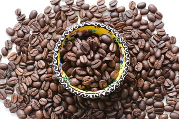 Processed coffee beans and tostao, on wooden background