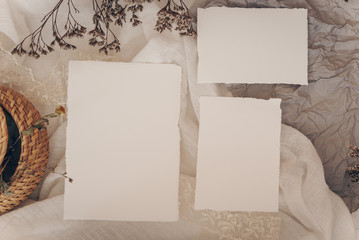 Wedding invitation mockup with dry plants , papers on white textile background. Top view, flat lay....
