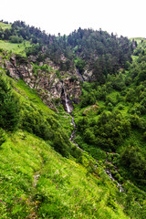 Fototapeta na wymiar waterfall flowing down a steep cliff in the mountains
