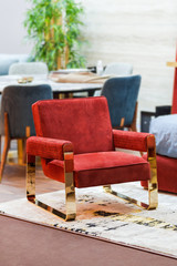Fashionable soft red armchair with brass legs in gold color