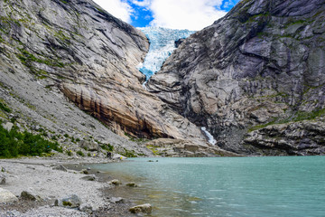 The Briksdalsbreen (Briksdal) glacier, which is the sleeve of the large Jostedalsbreen glacier in Norway. The melting glacier forms the Briksdalsbrevatnet lake with clear water.