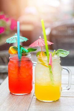 Summer yellow-orange lemonade with ice . Refreshing lemonade with oranges and mint on a wooden table