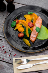 grilled salmon steak on a plate and a glass of beer