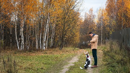 Cheerful guy communicating with dog in nature