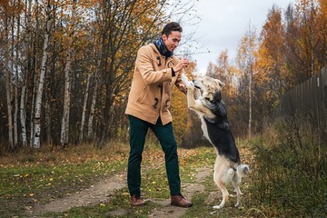 Cheerful guy communicating with dog in nature