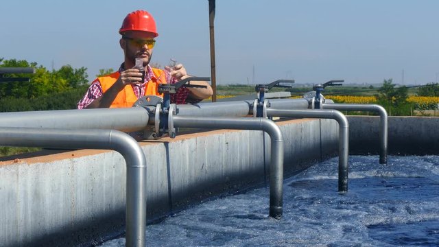    An engineer controlling a quality of water ,aerated activated sludge tank at a waste water treatment plant.  pollution