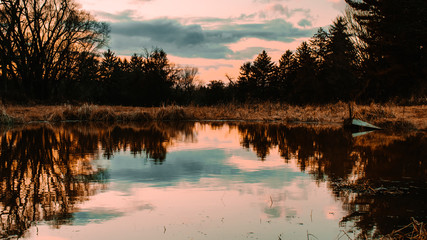 Fototapeta premium An Orange and Blue Sunset Reflecting Off of a Lake