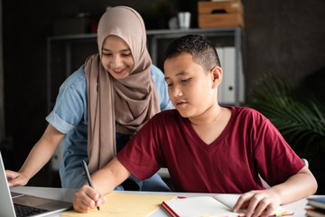 Naklejka premium The teacher teaching two muslim students doing activity together,at school,