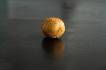 one kiwi on a wood table. Healthy lifestyle and wellbeing