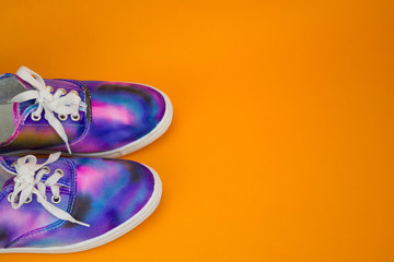pair of galaxy shoes on an orange background