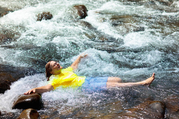 Woman swimming in mountain river.