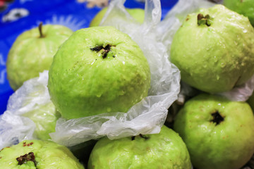 Fresh and green Guava fruit on the street market.Closeup fresh Guava in Thailand local market. A pile of organic guava on banana leaf plate.Fresh guava from organic farm.Thailand Local and natural pop