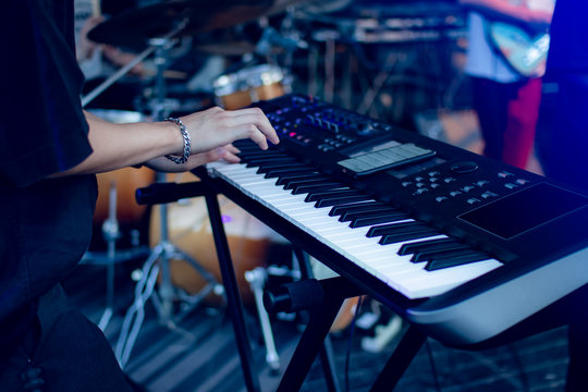 Musician playing on the keyboard synthesizer piano keys. Musician plays a musical instrument on the concert stage