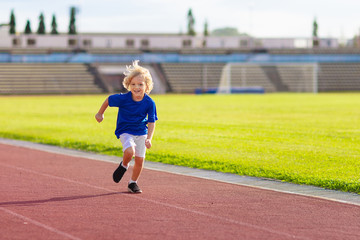 Child running in stadium. Kids run. Healthy sport.