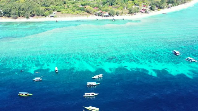 Luxury vacation concept. Boats moored in the crystal clear sea water near the tropical island. Gilli islands, Bali, Indonesia