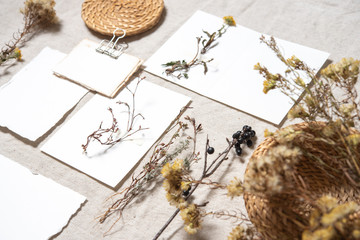 Wedding invitation mockup with dry plants , papers on textile background. Top view, flat lay. Wedding stationary. Perfect for presentation of your invitation, menu, greeting cards. Herbarium concept