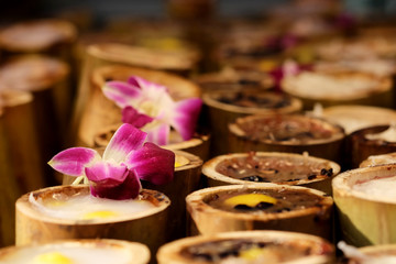 Sweet sticky rice in bamboo with decorated orchid on top. Street food is unique dining lifestyle in Bangkok, Thailand, Unhealthy from dust and dirtiness cause illness such as diarrhea.