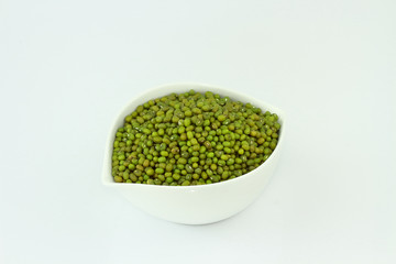dry mung beans in white ceramic bowl on white background. protiens. for packaging. advertising. editorial