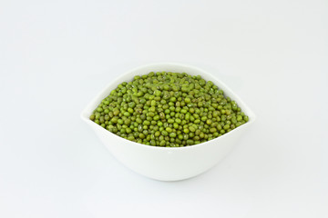 dry mung beans in white ceramic bowl on white background. protiens. for packaging. advertising. editorial