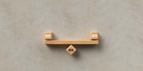 wooden blocks formed as a seesaw with the words WIN, WIN and DEAL on paper background
